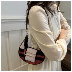 Detail of a retro color-block saddle bag with vintage check pattern and gold buckle