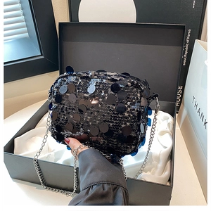 Detailed shot of black sequin crossbody bag in elegant gift box with silver chain strap