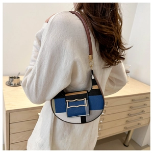 Detail of color-block crescent shoulder bag with vintage gold buckle on model