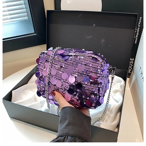 Close-up of purple sequin crossbody bag with silver chain strap on satin lining