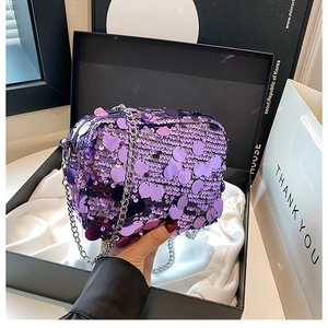 Macro detail of purple sequin mini bag with metallic silver chain strap and shiny texture