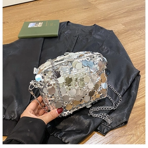 Detailed view of large silver sequins on a party chain bag with metallic reflections