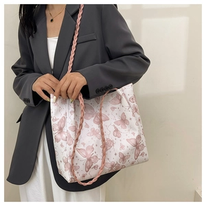 Close-up of pink woven shoulder straps and butterfly print on large tote bag