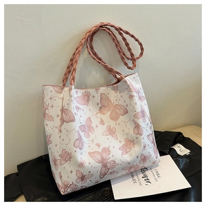Detail of pink woven leather handles on butterfly print tote bag with soft texture