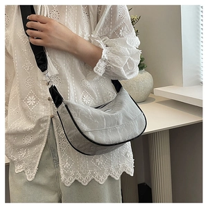 Detail view of silver hobo bag with unique marble texture and wide black shoulder strap