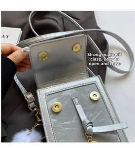 Detail shot of the silver crossbody bag showing the magnetic gold clasp closure