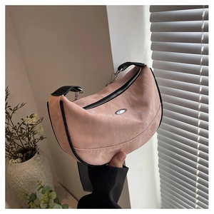 Detailed macro of pink crescent moon bag with silver oval hardware and black strap