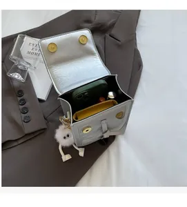 Vertical grey crossbody bag showing spacious interior with phone, wallet, and lipstick