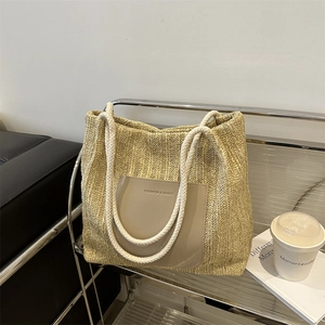 Large beige woven tote bag with rope handles and leather pocket for summer commuting