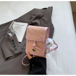 Details der rosa plissierten Leder-Handytasche mit Goldanhänger und Plüschmonster