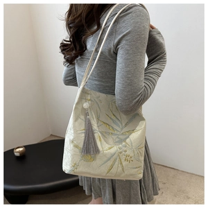 Detail of Chinese style embroidery tote bag with floral jacquard and grey tassel fringe