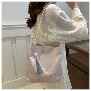 Dettaglio della borsa tote jacquard in stile cinese con ricamo paesaggistico e nappa