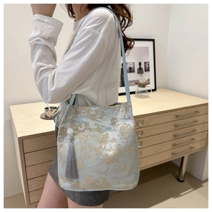 Detailed embroidery on light blue traditional Chinese tote bag with tassel charm