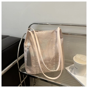 Detail of champagne pink satin tote bag with traditional Chinese embroidery and tassels