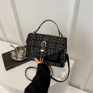 Elegant black and gold tweed crossbody bag with leather flap and golden buckle detail