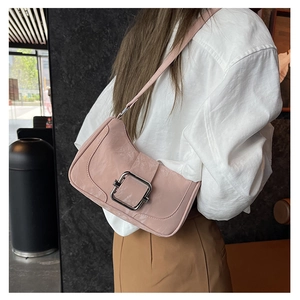 Detail of pink baguette shoulder bag with crinkled glossy finish and silver buckle