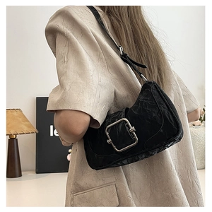 Detail of black textured leather shoulder bag with a large silver square metal buckle