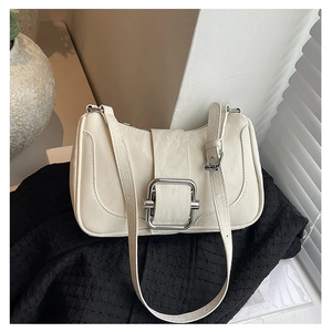 Detail of the cream shoulder bag featuring crinkled texture and silver metal buckle