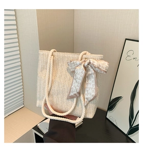 Détail du sac cabas tissé crème orné d'un ruban en soie avec motifs de cœurs élégants