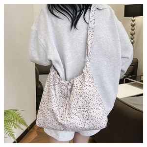 Detail view of pink floral canvas tote bag featuring adjustable strap and drawstring closure