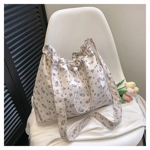 Détail du sac cabas floral à cordon montrant l'imprimé fleurs et la toile mate