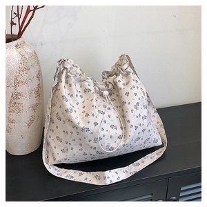 Vue détaillée du sac seau en toile à fleurs avec cordon de serrage et motifs floraux bleus