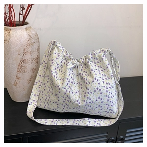Détail du sac cabas floral en toile avec cordon de serrage et motif fleurs mauves