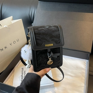 Elegante schwarze Samt-Umhängetasche für Handys mit Golddekor und Plüschanhänger im Karton