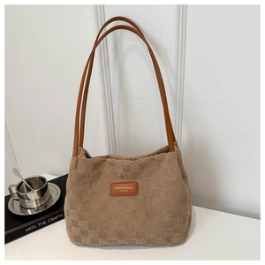 Detail of checkered embossed texture and brown leather strap on large nylon tote bag