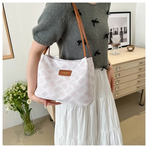 Detail showing the woven texture and brown leather strap of this stylish pink tote bag