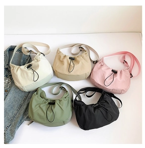 Flat lay of lightweight drawstring crossbody bags in five colors with adjustable straps