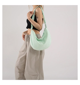 Close-up of mint green hobo bag with honeycomb textured fabric and wide shoulder strap
