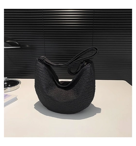 Detail of the black pleated texture on the crescent shoulder bag with modern design