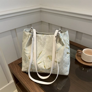 Off-white canvas tote bag with blue bird and bamboo leaf prints and long leather straps