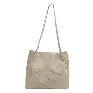 Beige tote bag featuring golden blue bamboo and bird patterns on a white background