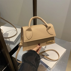 Chic beige crossbody square bag with gold logo shown held in hand for size display
