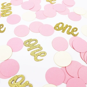 Détail de confettis roses et dorés avec lettres one scintillantes pour premier anniversaire bébé