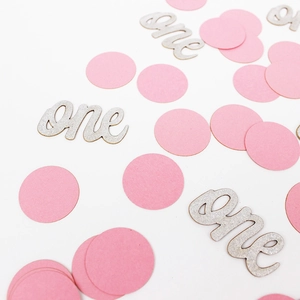 Gros plan de confettis roses et découpe argentée scintillante 'one' pour fête de 1 an