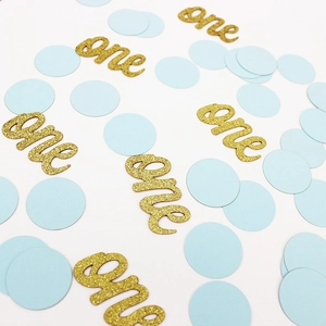 Gros plan sur les confettis dorés 'one' et cercles bleu clair pour décoration de fête