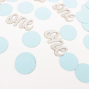 Détail de confettis ronds bleu clair et lettres 'one' pailletées argent pour anniversaire