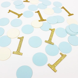 Gros plan de confettis ronds bleus et blancs avec paillettes dorées numéro un