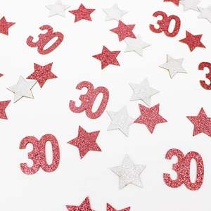 Primer plano de confeti de estrella y número 30 oro rosa para decoración de mesa de fiesta