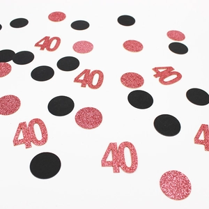 Dettaglio di coriandoli glitter oro rosa numero 40 e pois neri per decorazioni da tavolo