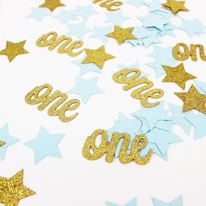 Vue macro des confettis 'one' dorés et étoiles bleues pour anniversaire de bébé