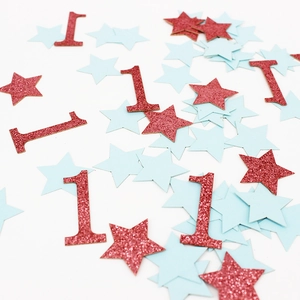 Détail de confettis chiffre 1 pailleté rouge et étoiles bleues pour fête d'anniversaire