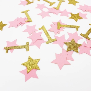 Détail de confettis étoiles roses et chiffre un à paillettes dorées pour premier anniversaire