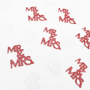 Macro shot of rose gold glitter Mr & Mrs confetti decorations for wedding tables