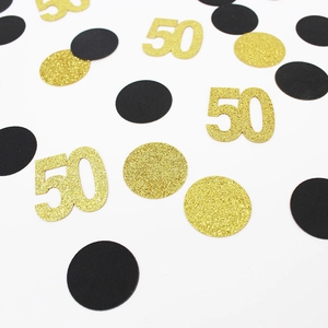 Detail van zwarte en glitter goudkleurige confetti voor een 50ste verjaardagsfeestje