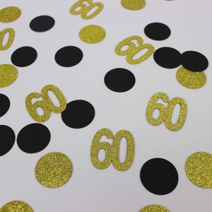 Detailopname van zwarte en gouden 60ste verjaardag confetti met glitters op witte achtergrond