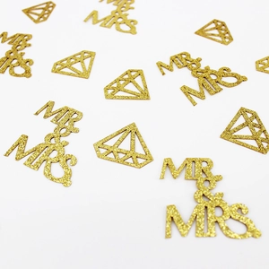 Golden glitter Mr & Mrs and diamond shaped wedding confetti on white background